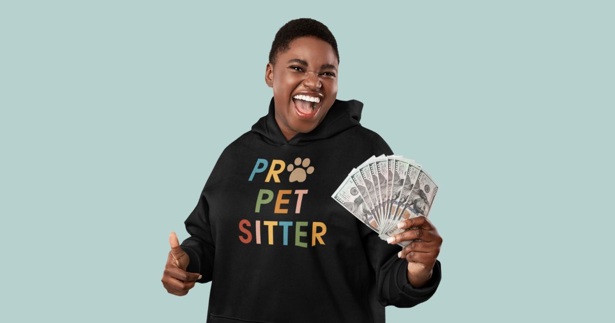 Woman with short cropped hair wearing a black colored hoodie with PRO PET SITTER on the front, holding one hundred dollar bills
